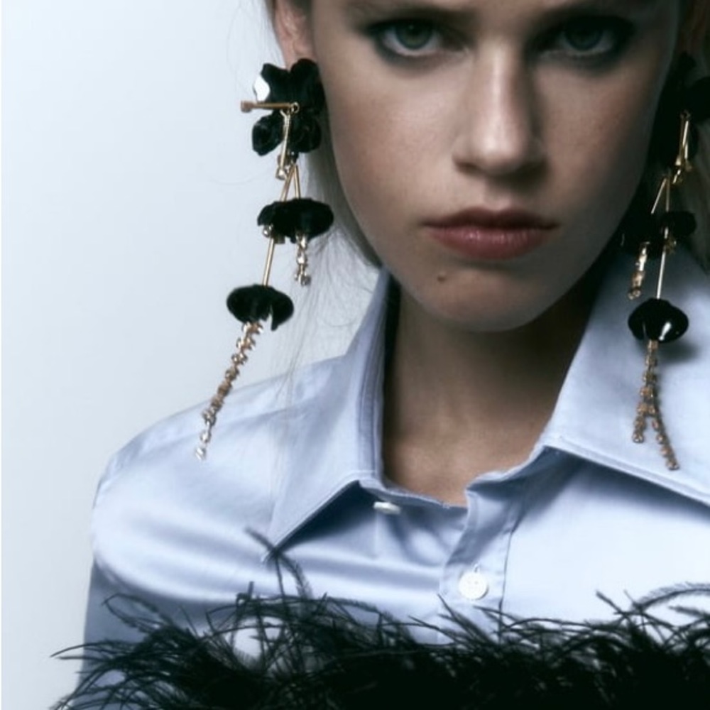 Flower shaped metal drop statement earrings with jewel appliqué.